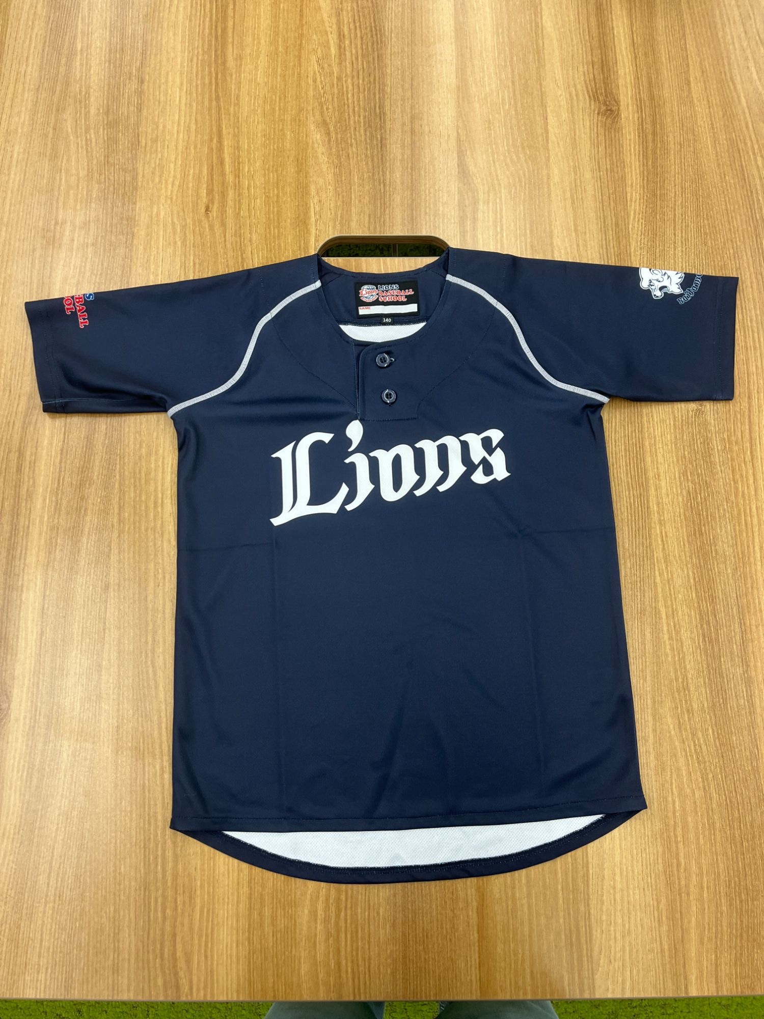 ライオンズベースボールスクール ユニフォーム上 表面 (ネイビー × Lions ロゴ前面、サイズ 140)