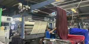 染色工程で濃色の生地を確認する作業者