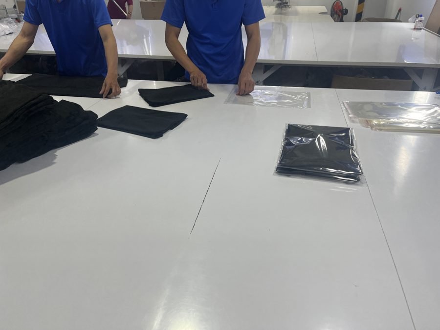 OPP 袋に 1 枚ずつ個包装された製品と、包装作業をしているスタッフ
