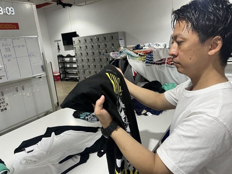 代表が渡航時に自社工場でプリントの発色と仕上がりを確認している様子